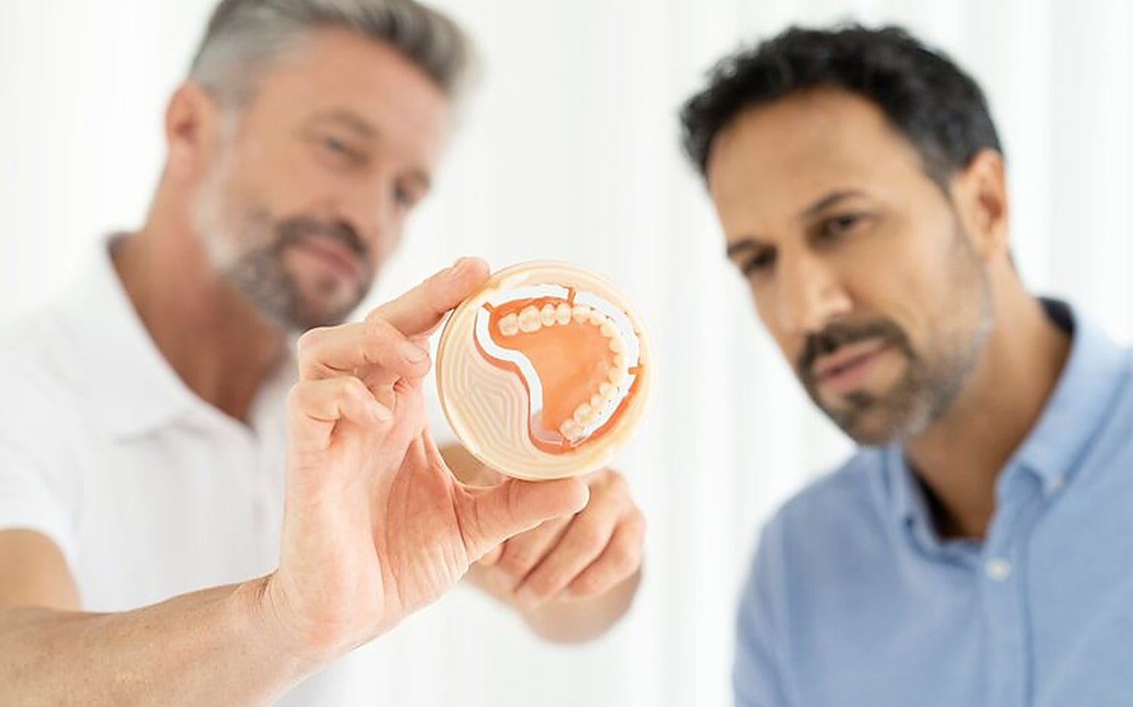 Specialistë dentarë duke shqyrtuar një disk Ivotion nga Ivoclar